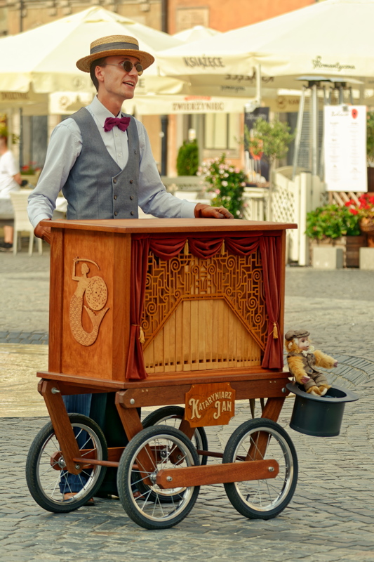 11 - The street performer Kataryniarz Jan operating a traditional Polish barrel organ on the streets of Warsaw